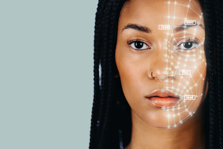 a young Black woman with long braided hair facing the camera with a web of white lines on the left side of her face