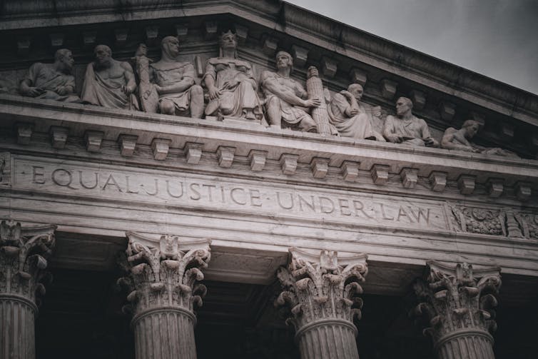 The top of a fancy government building, with the phrase 'EQUAL JUSTICE UNDER LAW' inscribed in it.