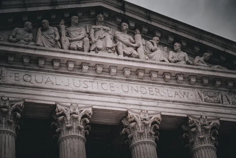 The top of a fancy government building, with the phrase 'EQUAL JUSTICE UNDER LAW' inscribed in it.