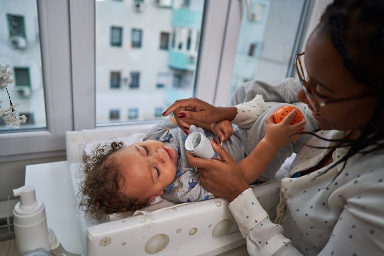 A person applying ointment to a child's face