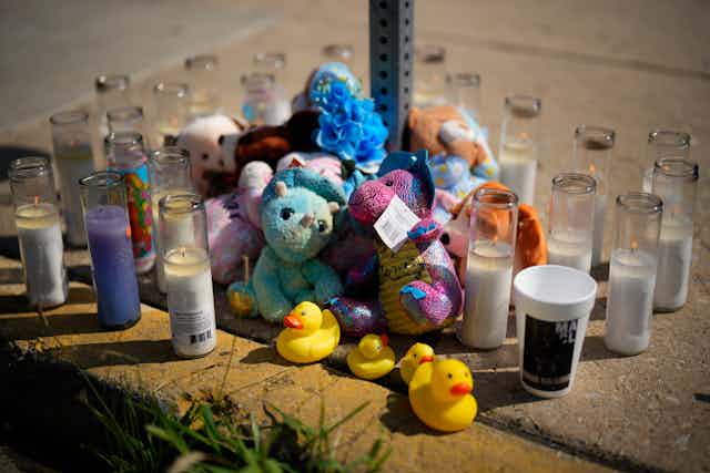 Stuffed animals and candles arranged on a Philadelphia sidewalk for victim of mass shooting.