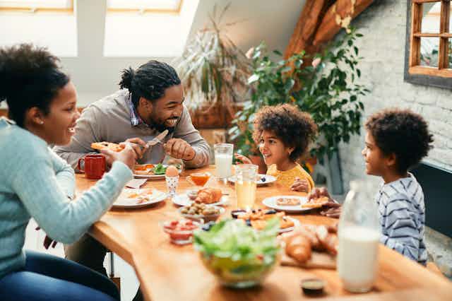 A happy family enjoys a meal at the dinner table.