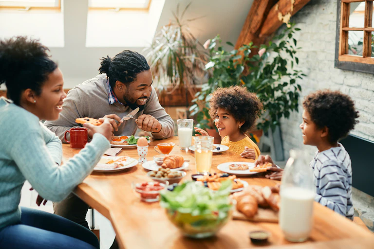 A happy family enjoys a meal at the dinner table.