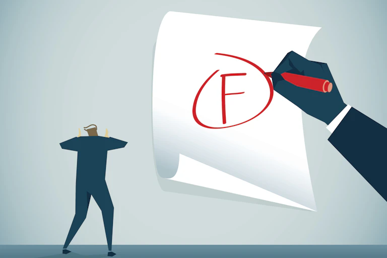 A man next to a paper with a person writing an 'F' on it.