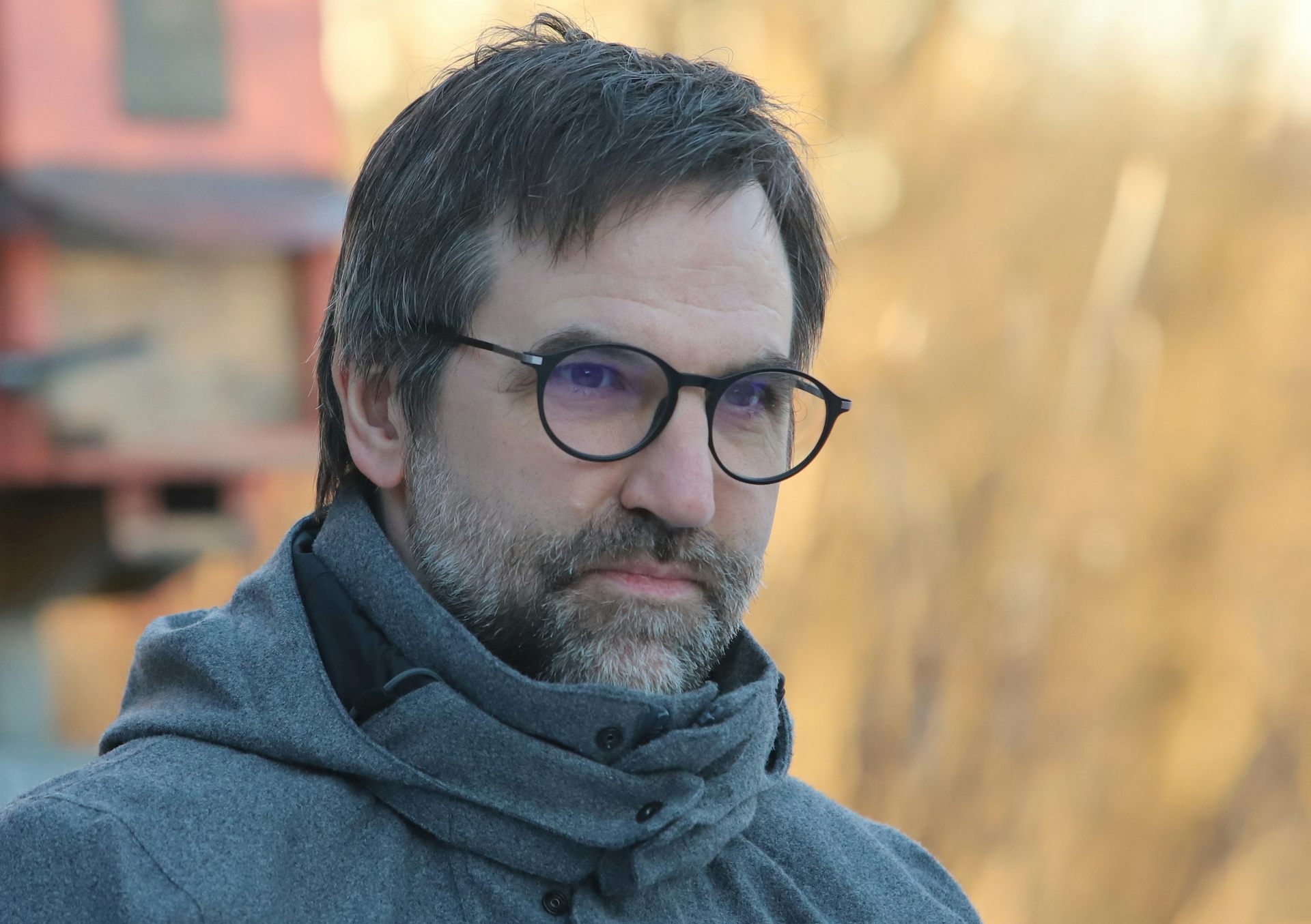 A man with glasses and a beard in a winter jacket.