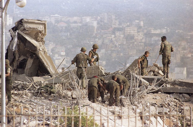 Men search through rubble.