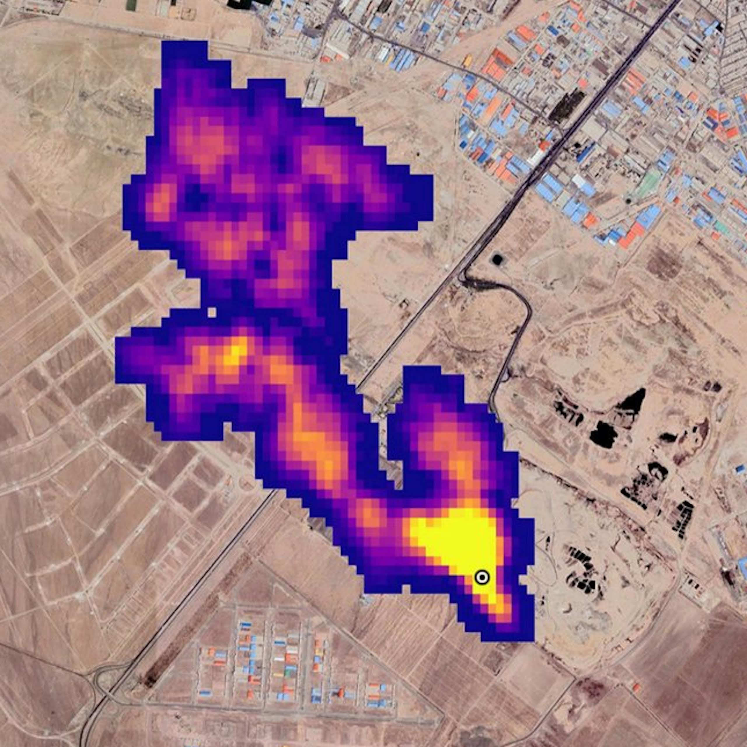 A colored image show methane leaking form a source with buildings nearby.