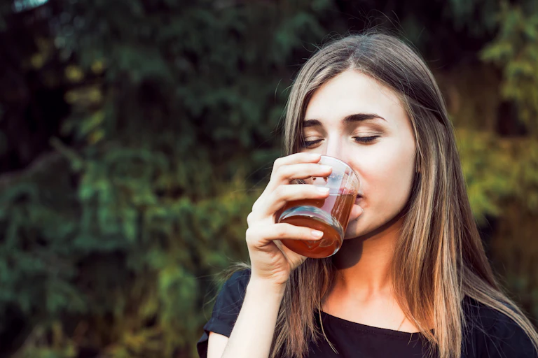 Woman drinks glass of apple cider vinegar