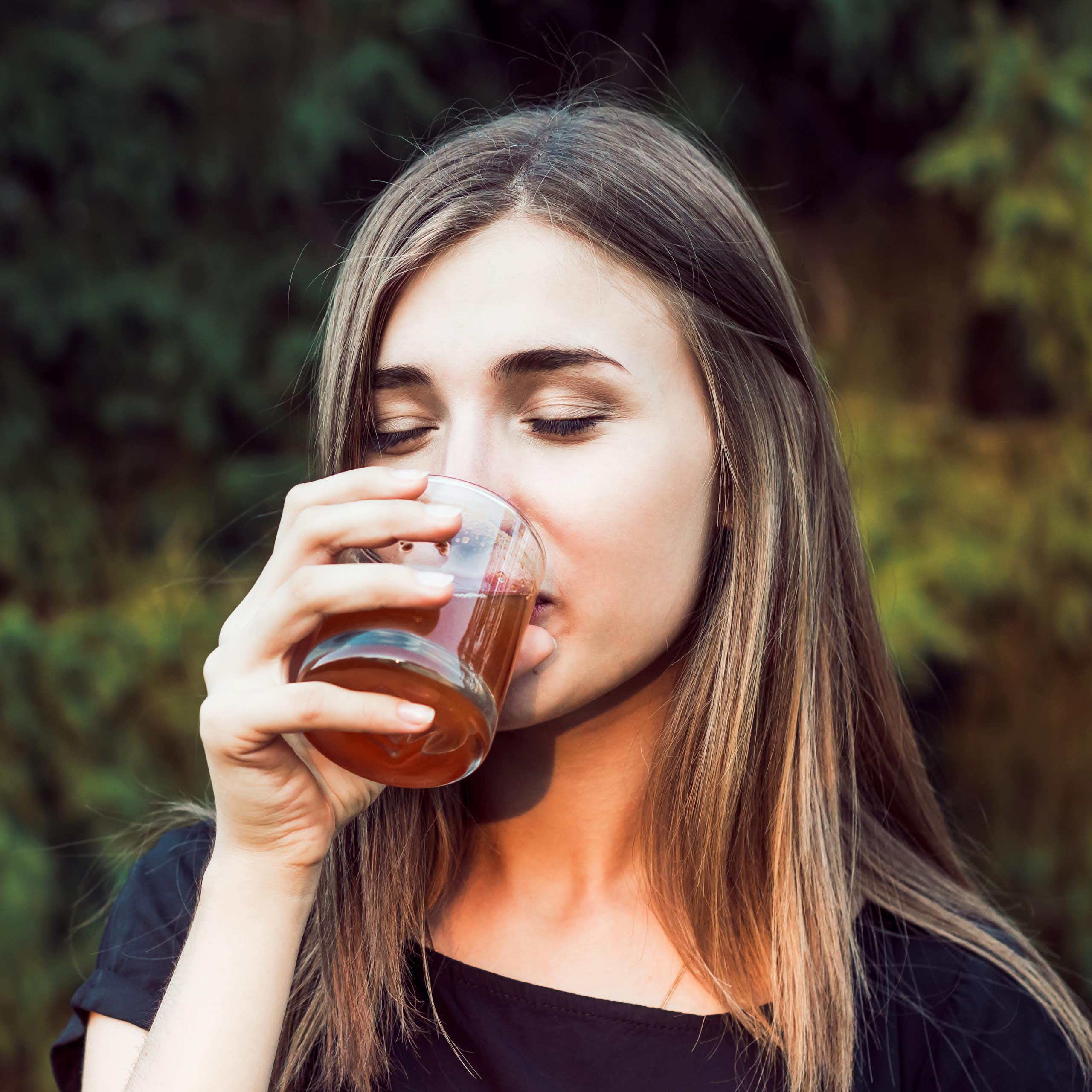Woman drinks glass of apple cider vinegar