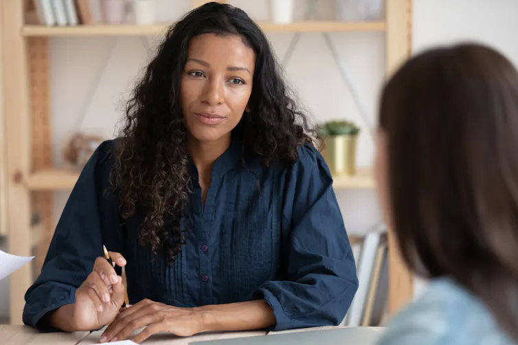 Two women sitting at a table talking.