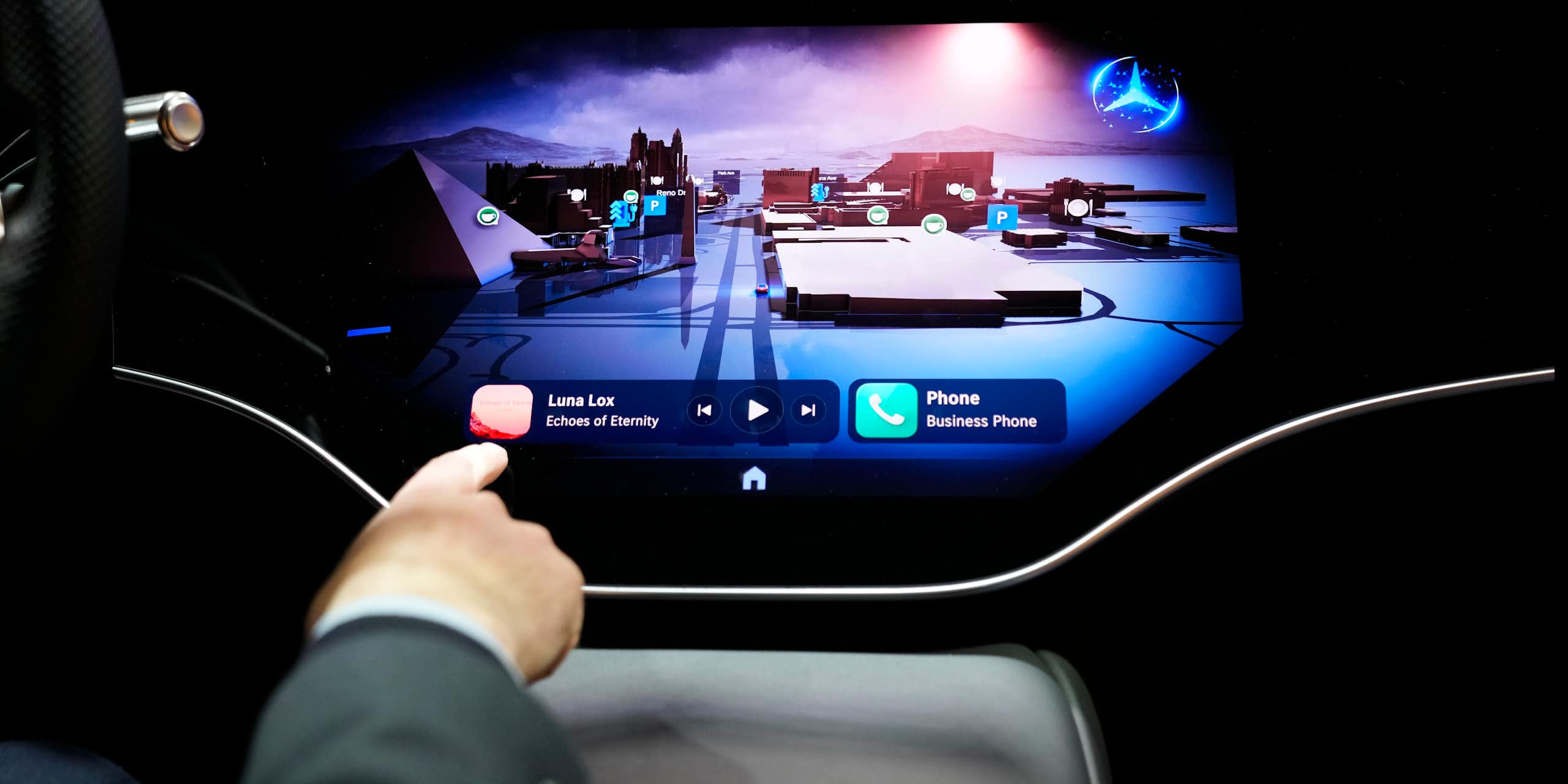 a hand points to a virtual button on a display screen on a car dashboard.