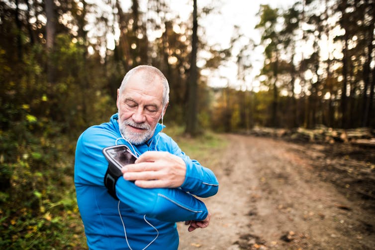 Man in active gear checks phone in outdoor setting