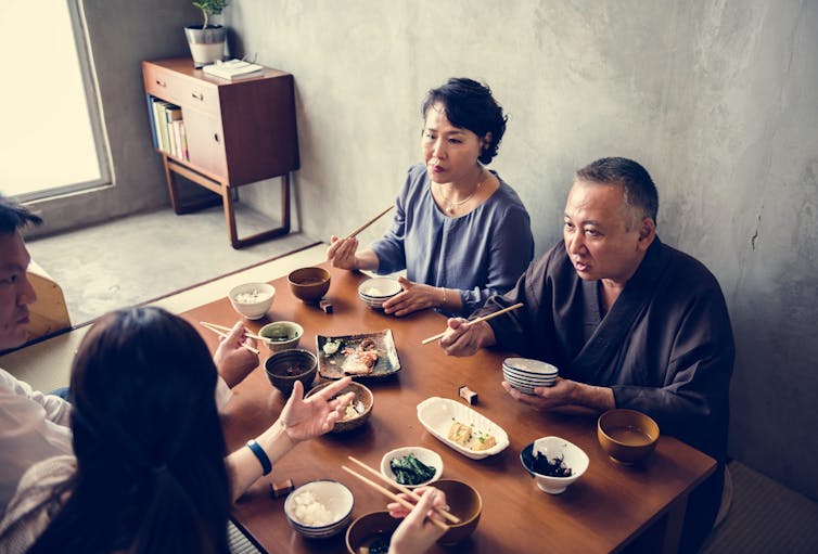 A Japanese family eat a meal together.