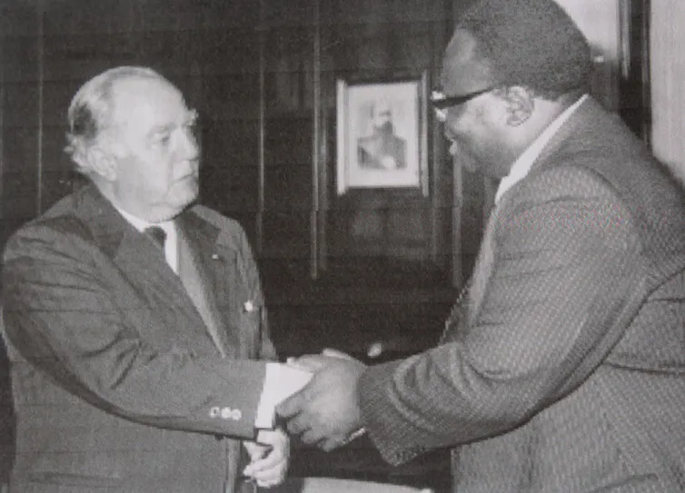 Two men hold each other in greeting.