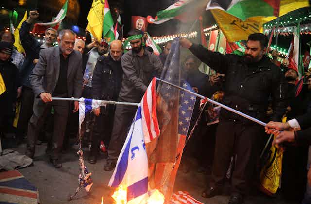 Iranian protesters burn US and Israeli flags