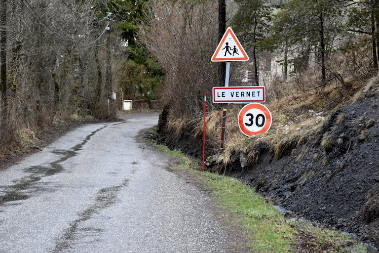 panneaux indiquant l'entrée du Vernet, village des Alpes du sud, ainsi qu'une limitation de vitesse et la présence d'enfants