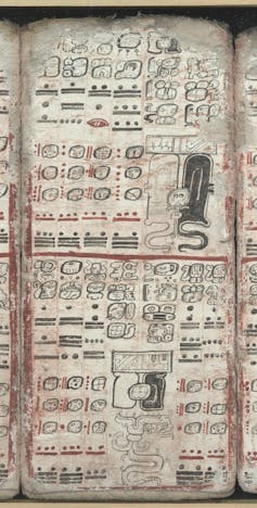 Un manuscrit ancien couvert de caractères et d’illustrations en noir et rouge.