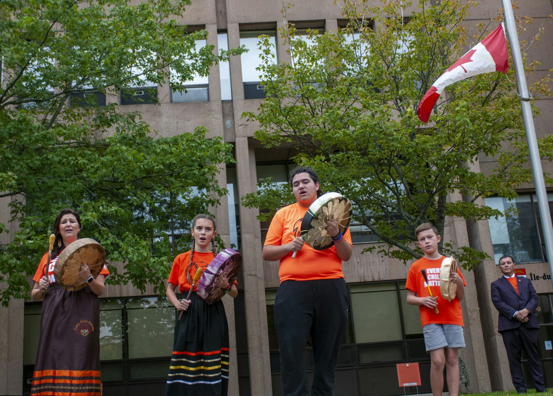 Drummers seen in orange shirts.