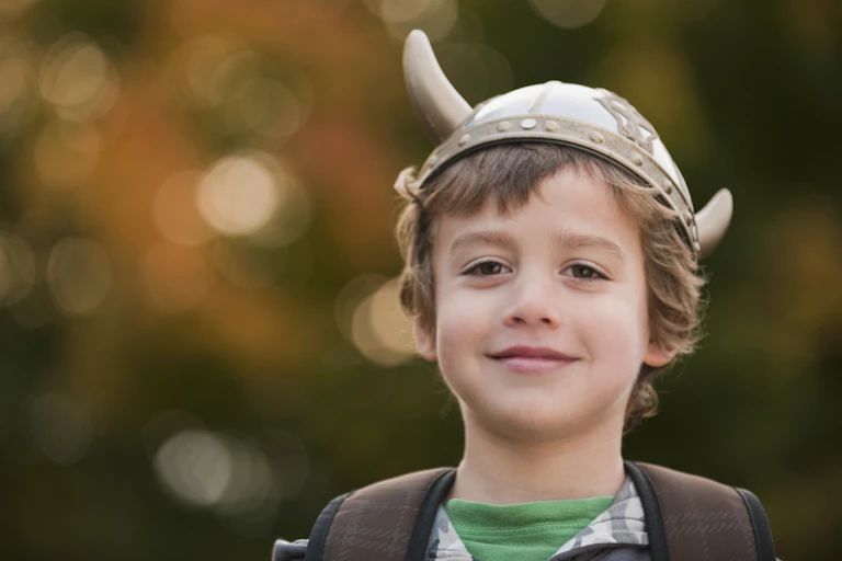smiling boy wearing Viking hat with horns