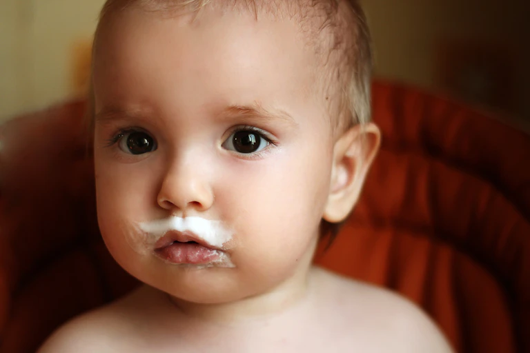 Cute baby with milk around mouth, including a milk mustache