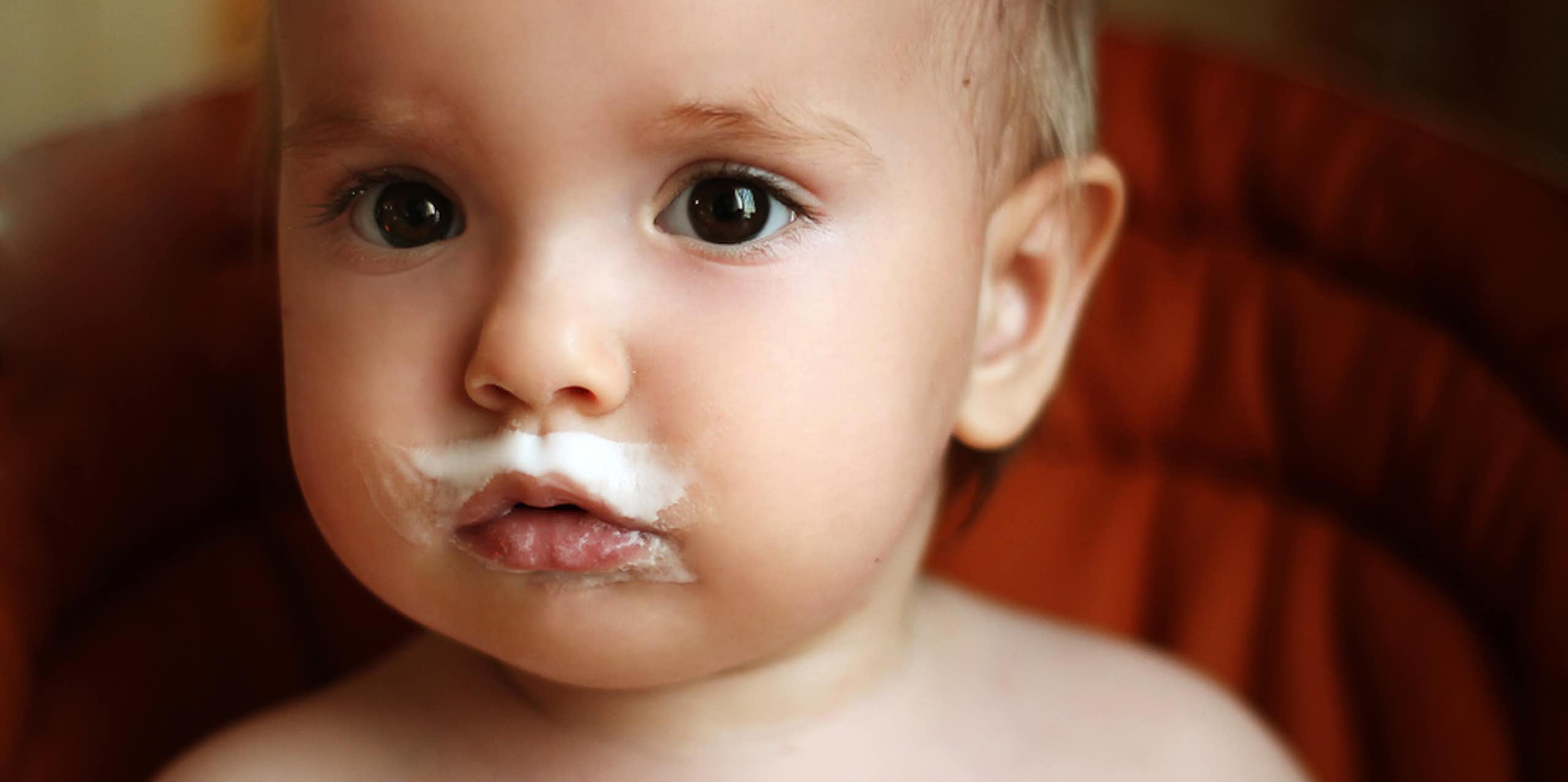 Cute baby with milk around mouth, including a milk mustache