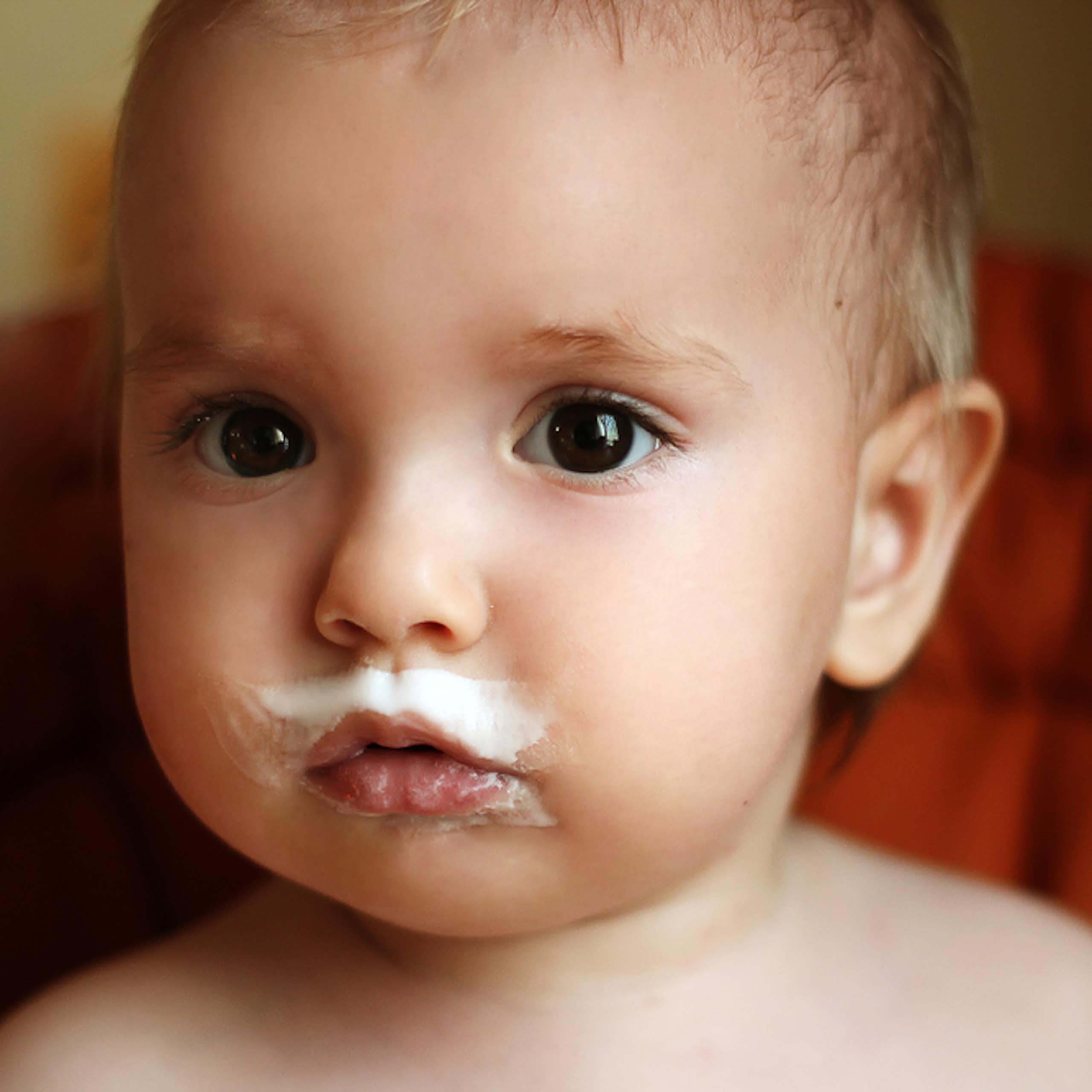 Cute baby with milk around mouth, including a milk mustache