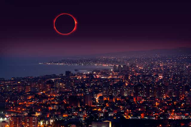 an eclipsed sun over a dark cityscape
