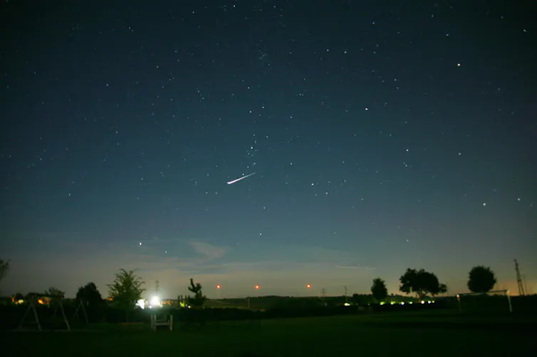 a night sky with a short streak of light