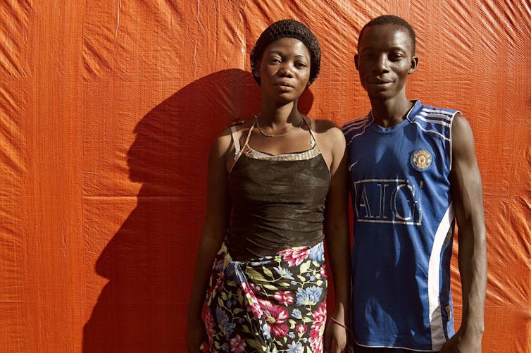 A young woman and men standing side by side.