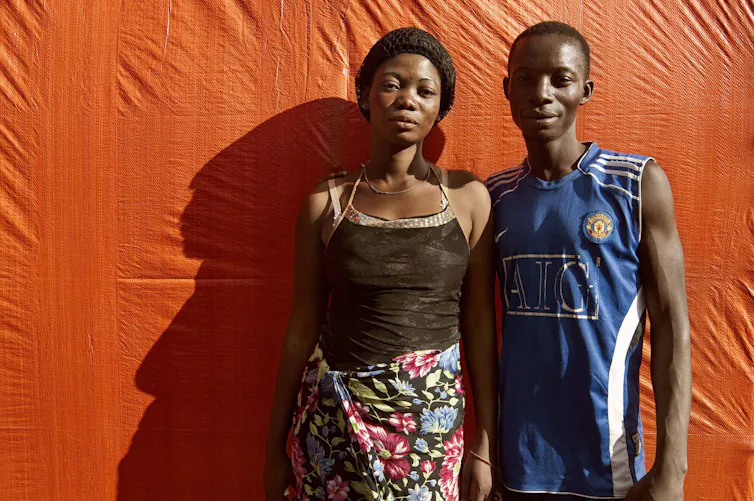 A young woman and men standing side by side.