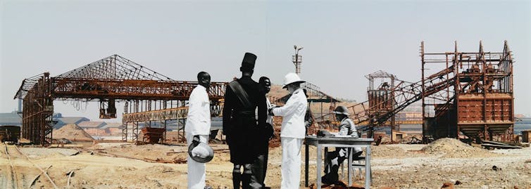 Men in colonial-era garb in front of a mine shaft.