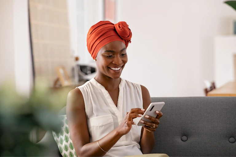 Photo of a woman wearing a head scarf texting.