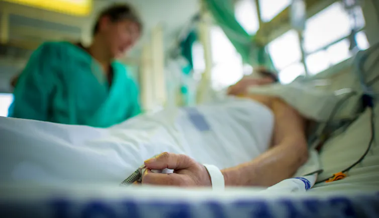 A doctor comforting an intensive care patient.