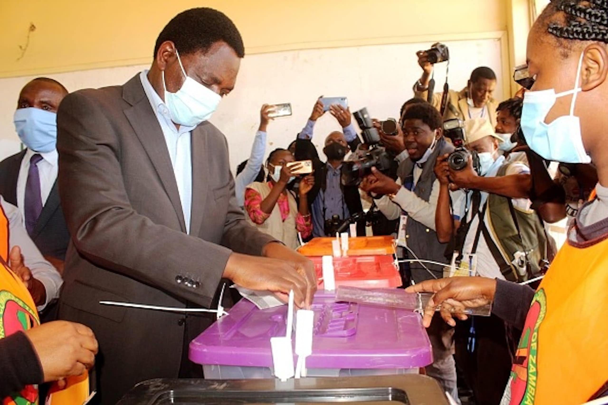 A man wearing a Covid mask casts his vote.