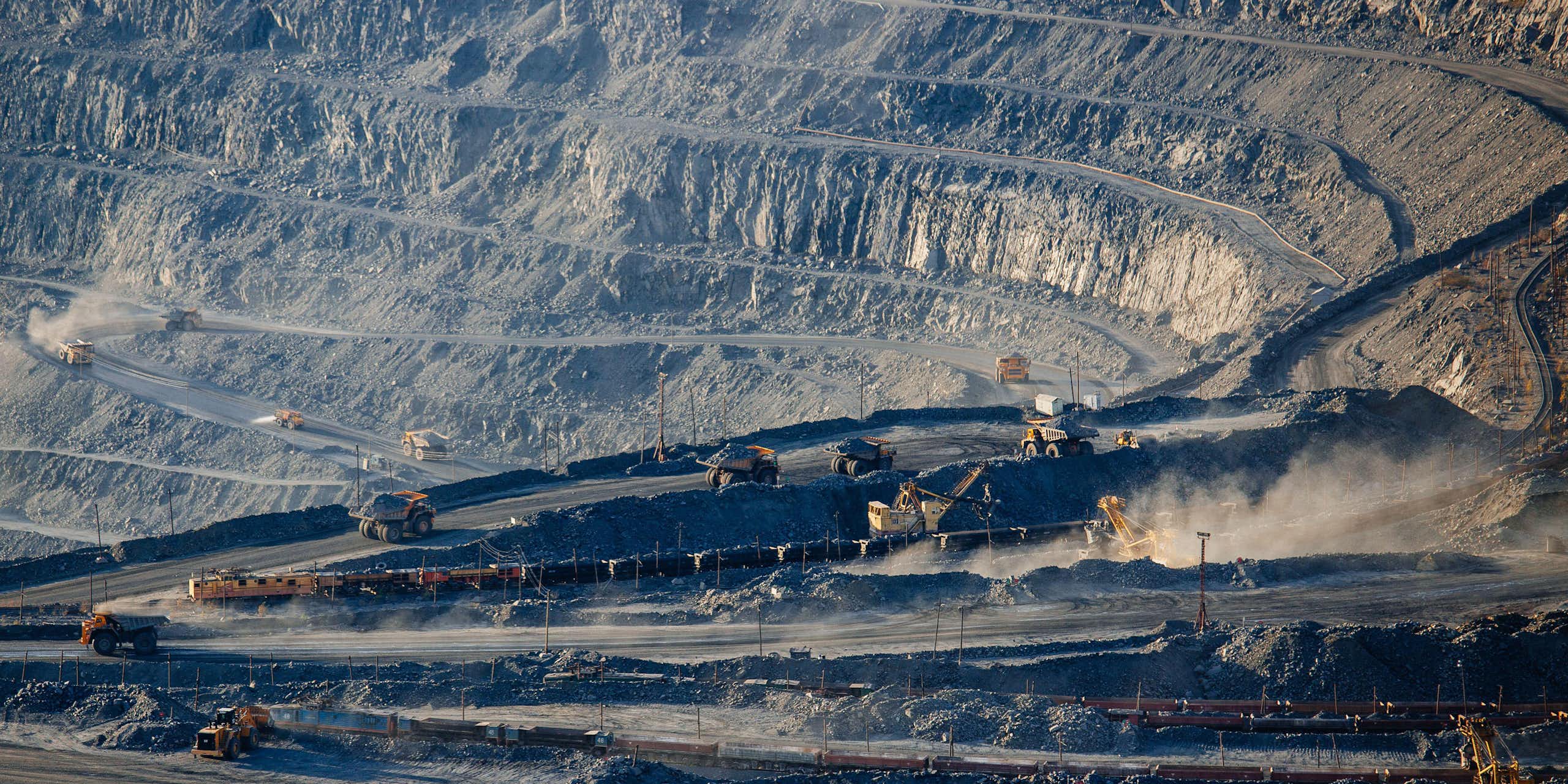 Open pit mine with trucks on a hill side. 