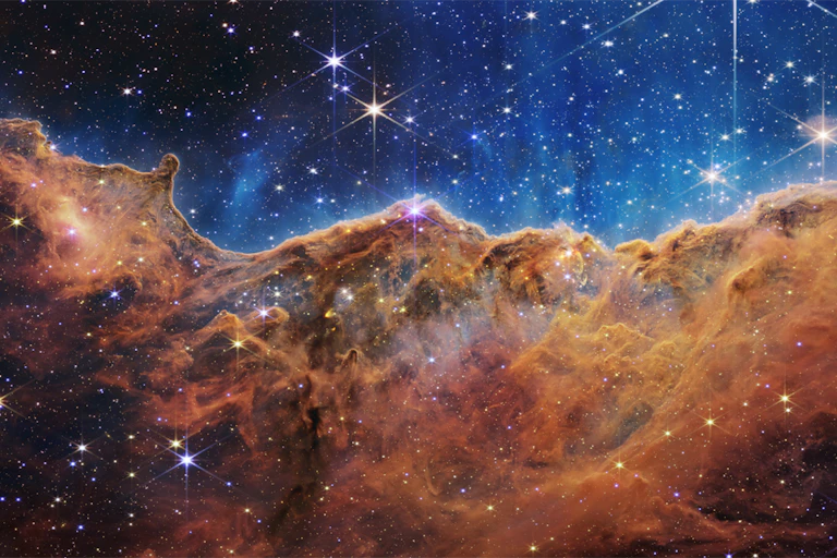 Galactic clouds against a dark, star-speckled sky.