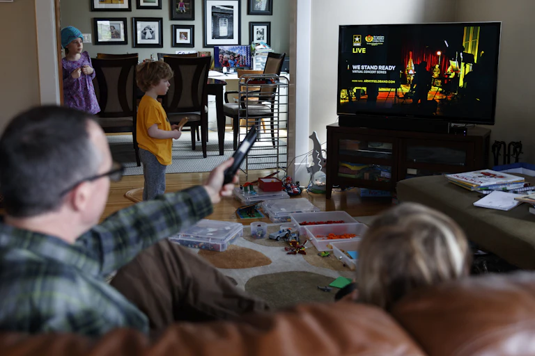 Man watching TV with his kids.