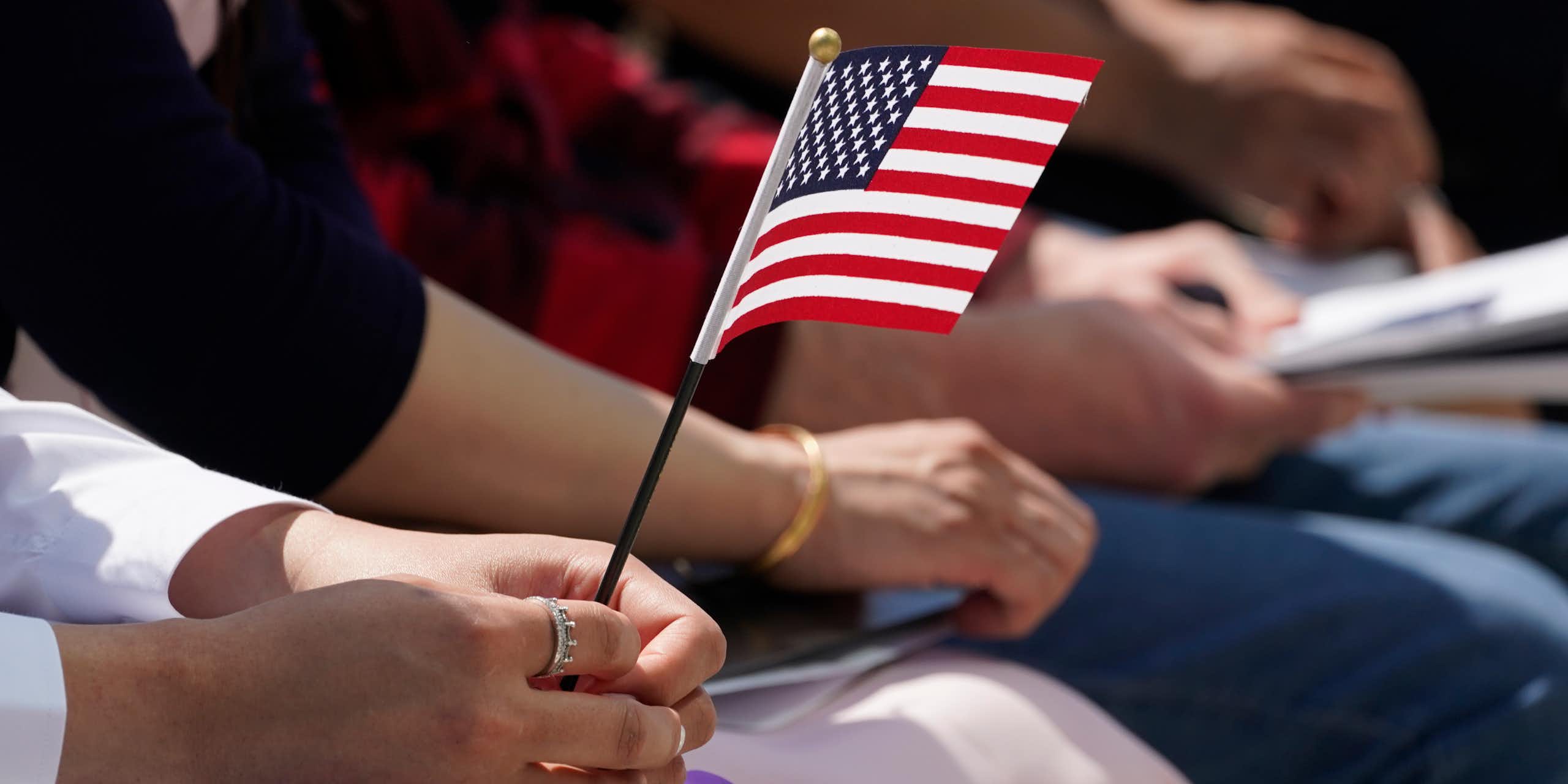 Close up of a hand holding a small American flag