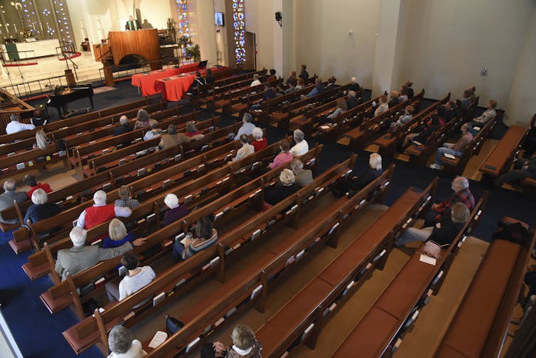 A bird's-eye view of a church sanctuary, with half or more of the pews empty.