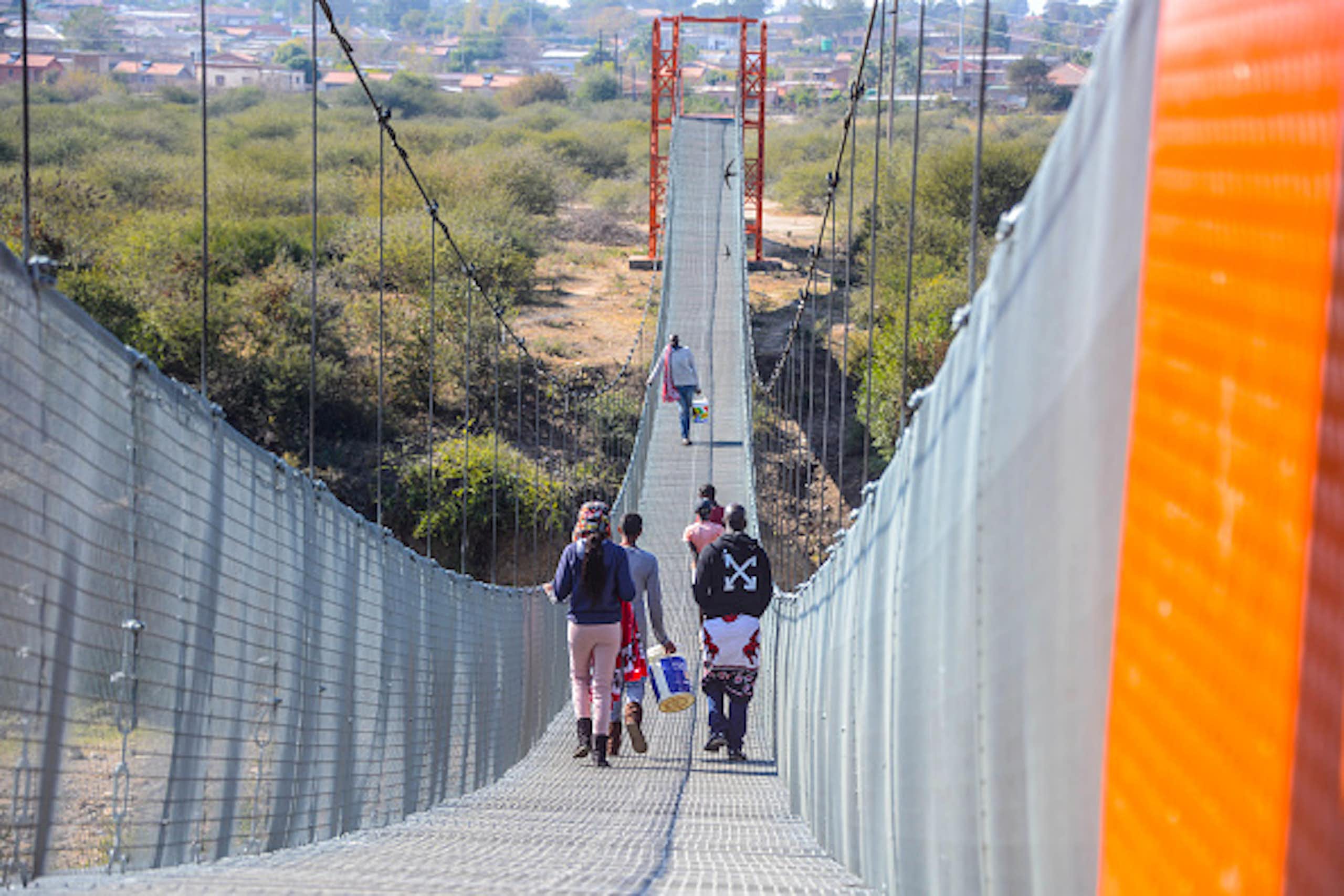People walking across a suspension bridge