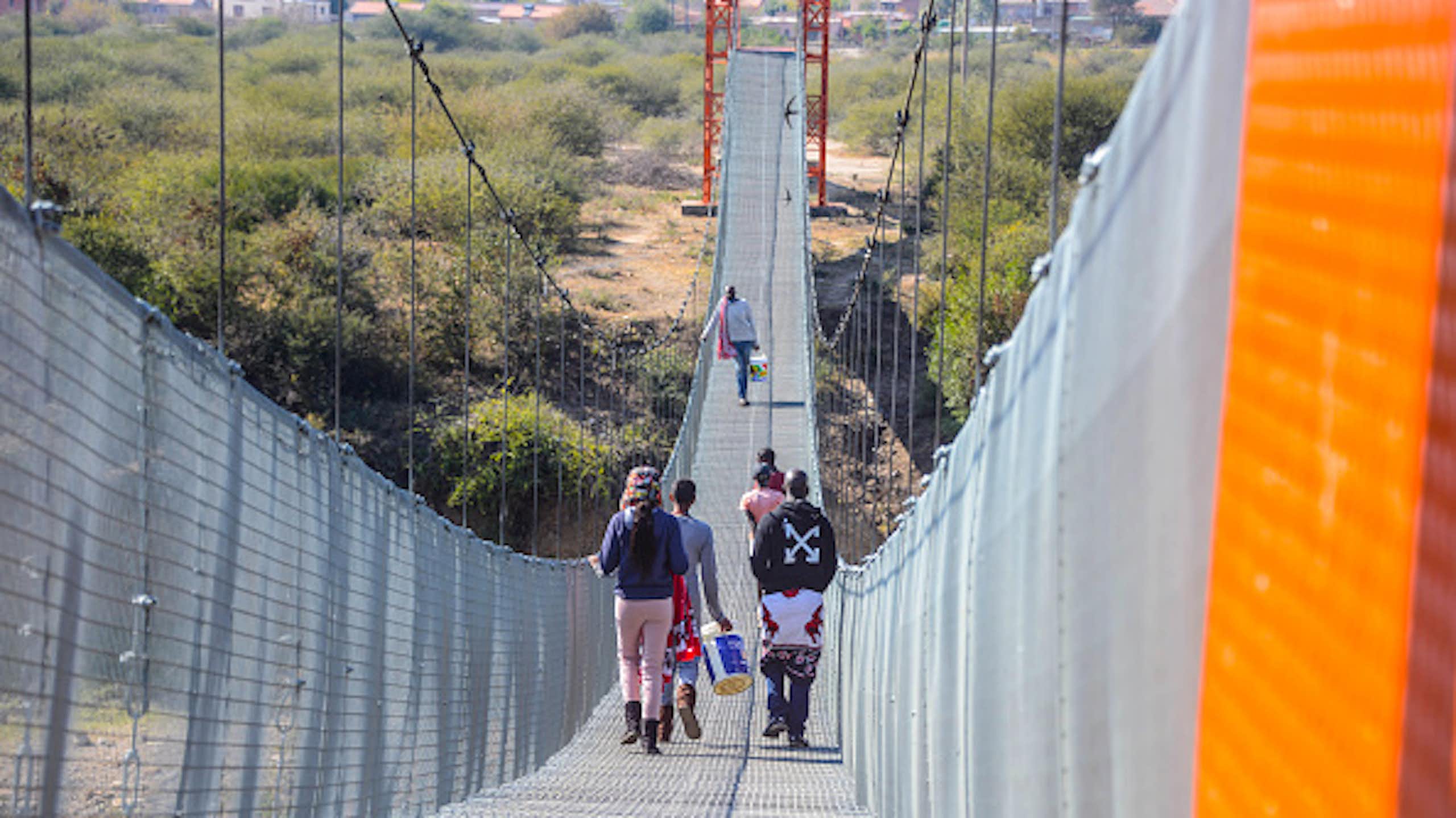 People walking across a suspension bridge