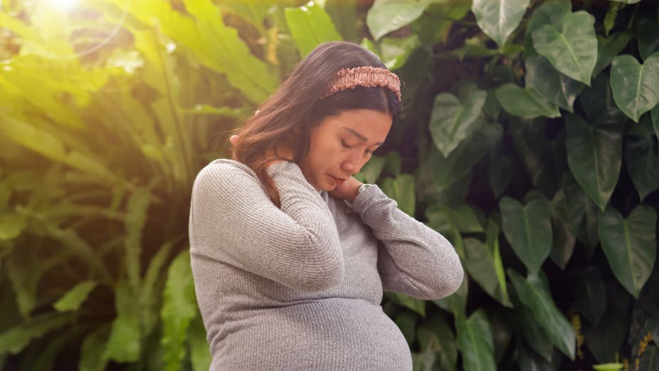 A pregnant woman looking exhausted or sad.