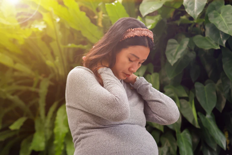 A pregnant woman looking exhausted or sad.
