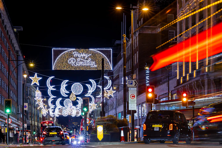 A night scene of a street with festive lighting.