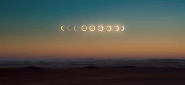 a desert sky with all phases of the solar eclipse in a row