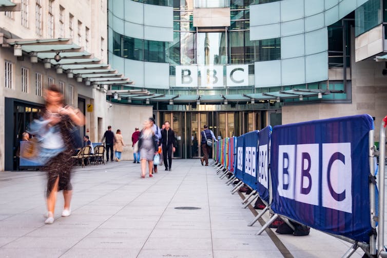 Front of BBC headquarters building with people walking in and out