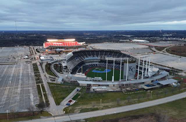 An aerial view of a baseball stadium and football stadium near one another.