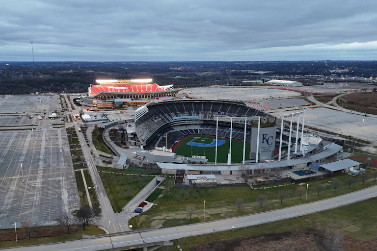 An aerial view of a baseball stadium and football stadium near one another.