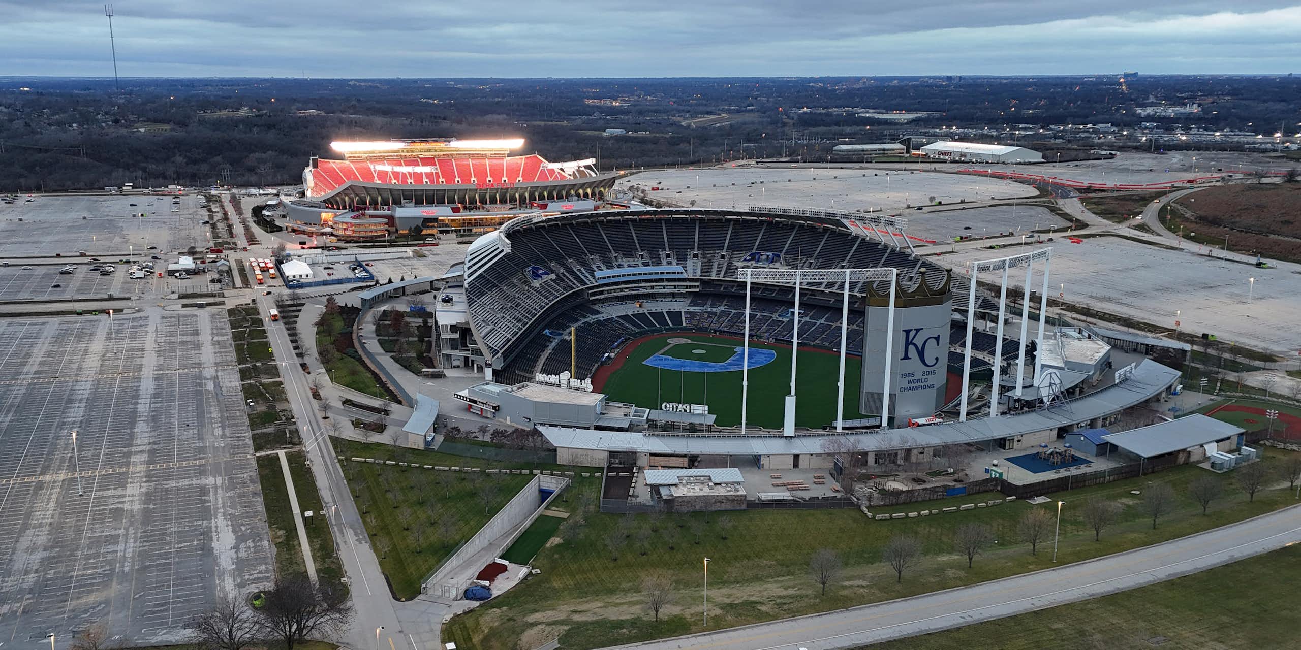 An aerial view of a baseball stadium and football stadium near one another.