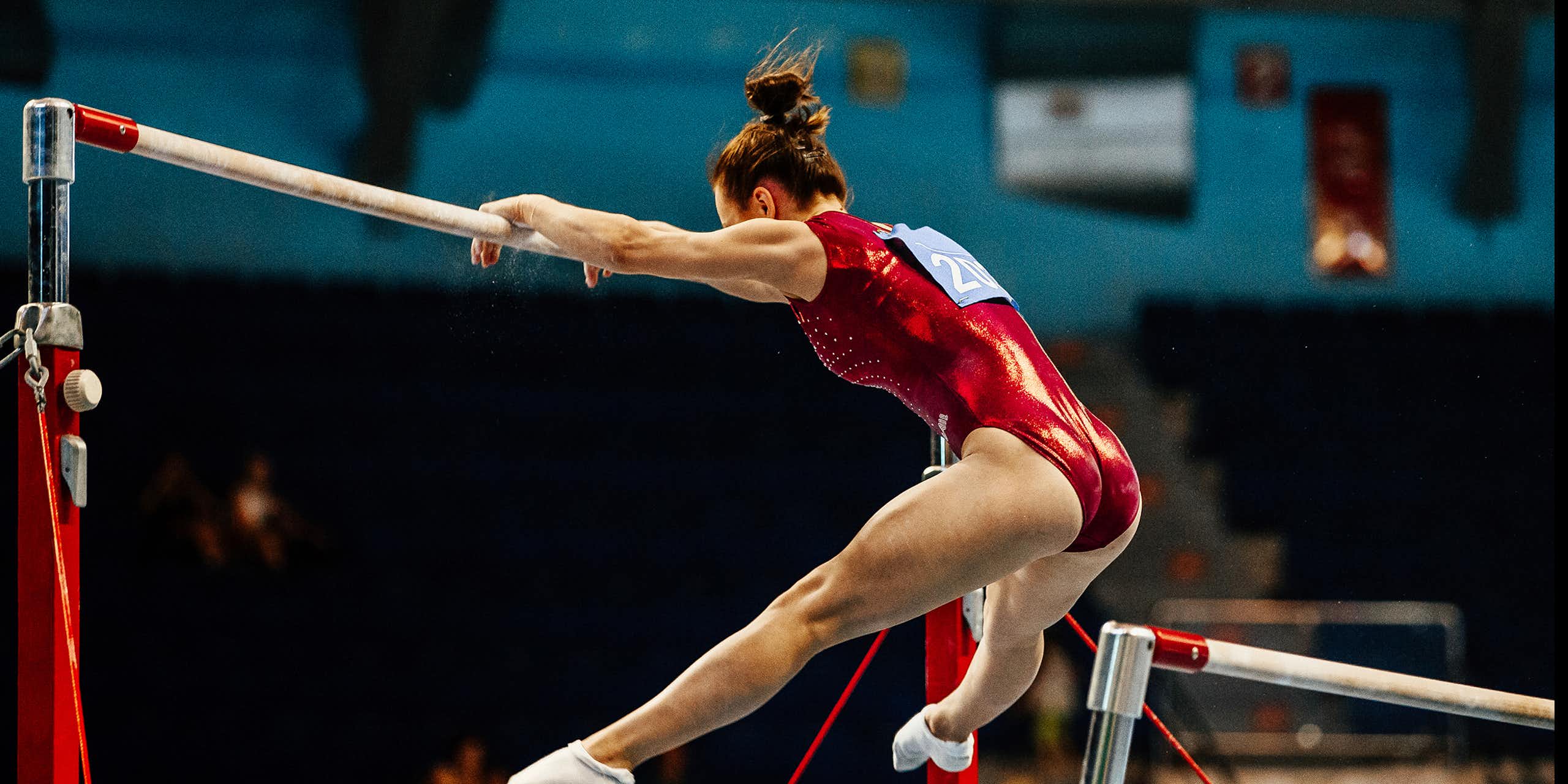 Une gymnaste effectue un exercice sur des barres asymétriques lors d'une compétition.